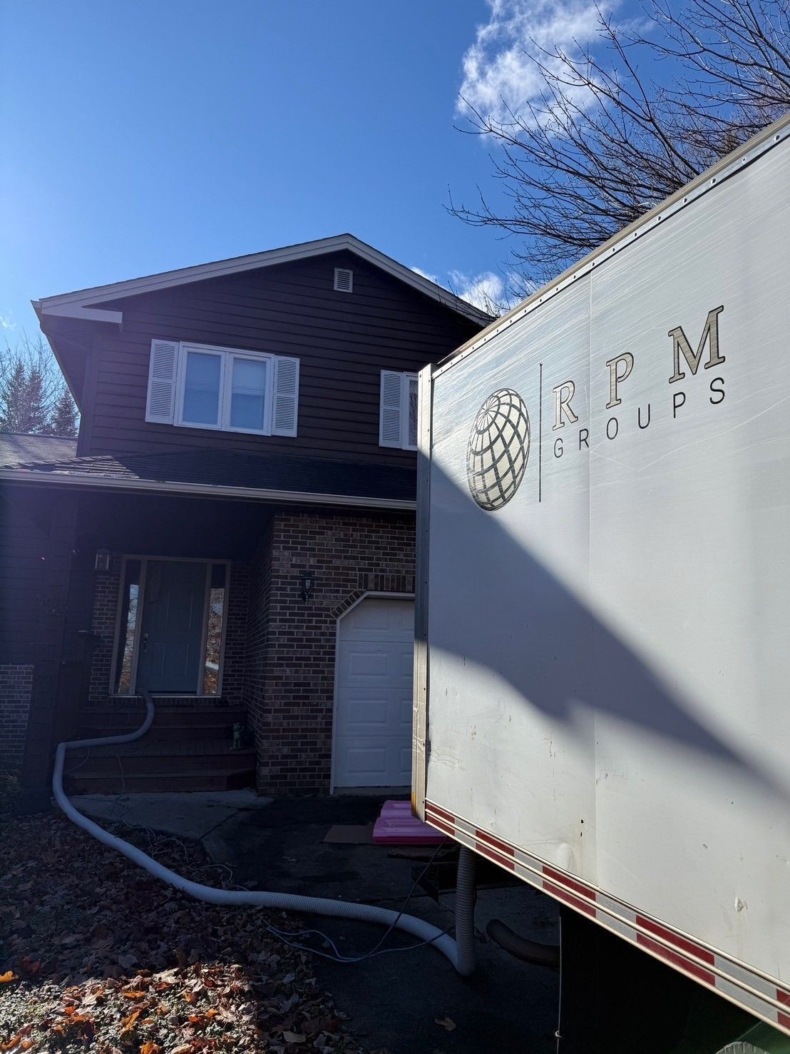 A man is kneeling down under a sink in a kitchen.