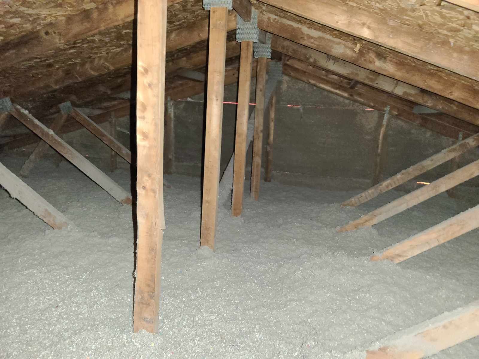 An attic with a lot of wooden beams and insulation