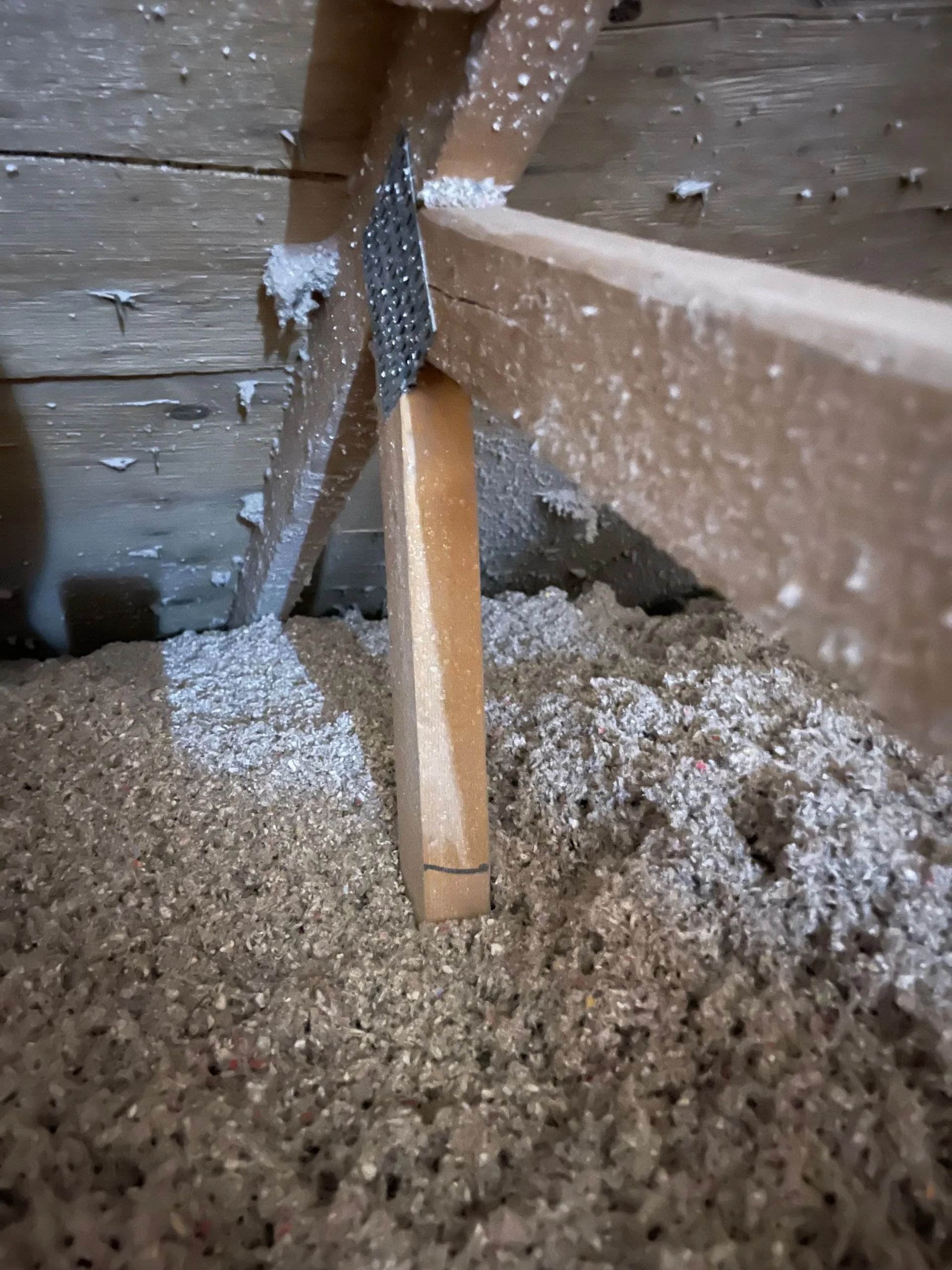 A wooden beam is sitting on top of a pile of wood shavings.