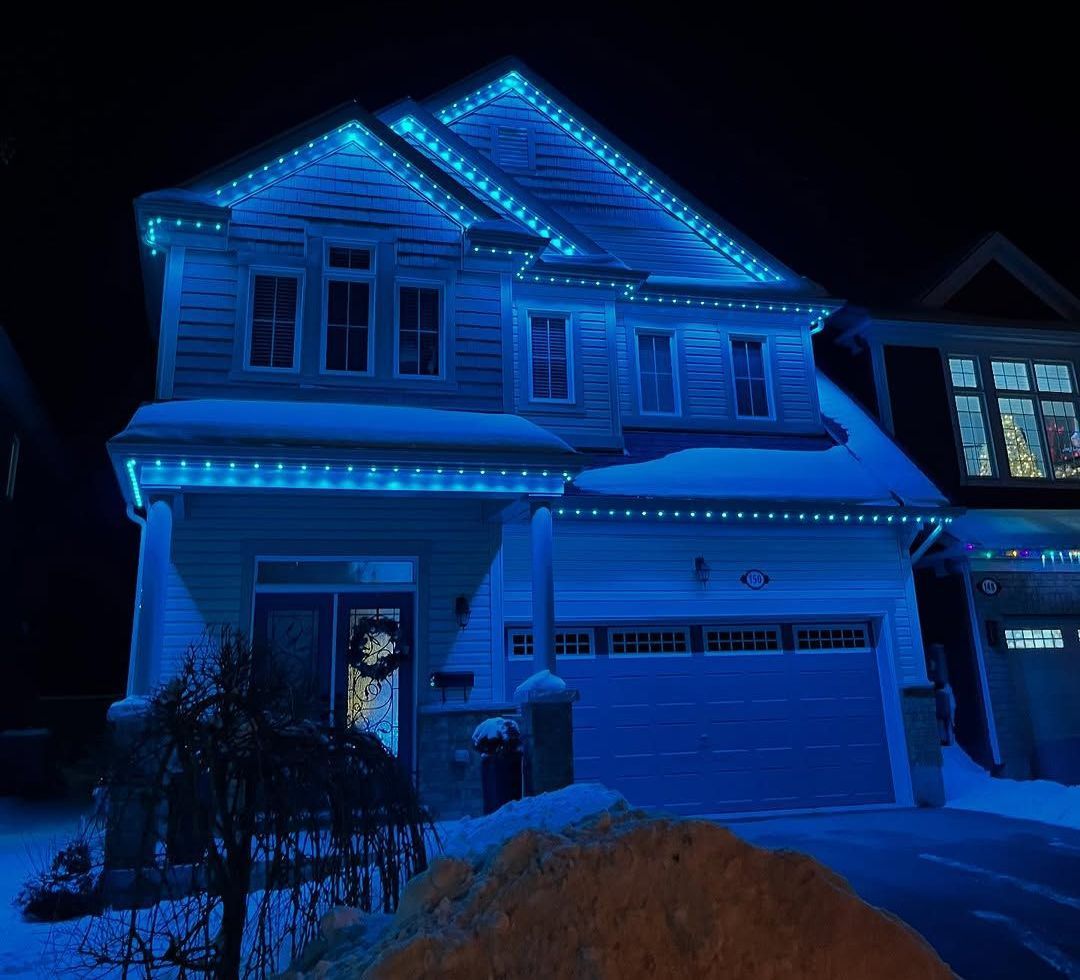 A house with christmas lights on it is lit up at night.