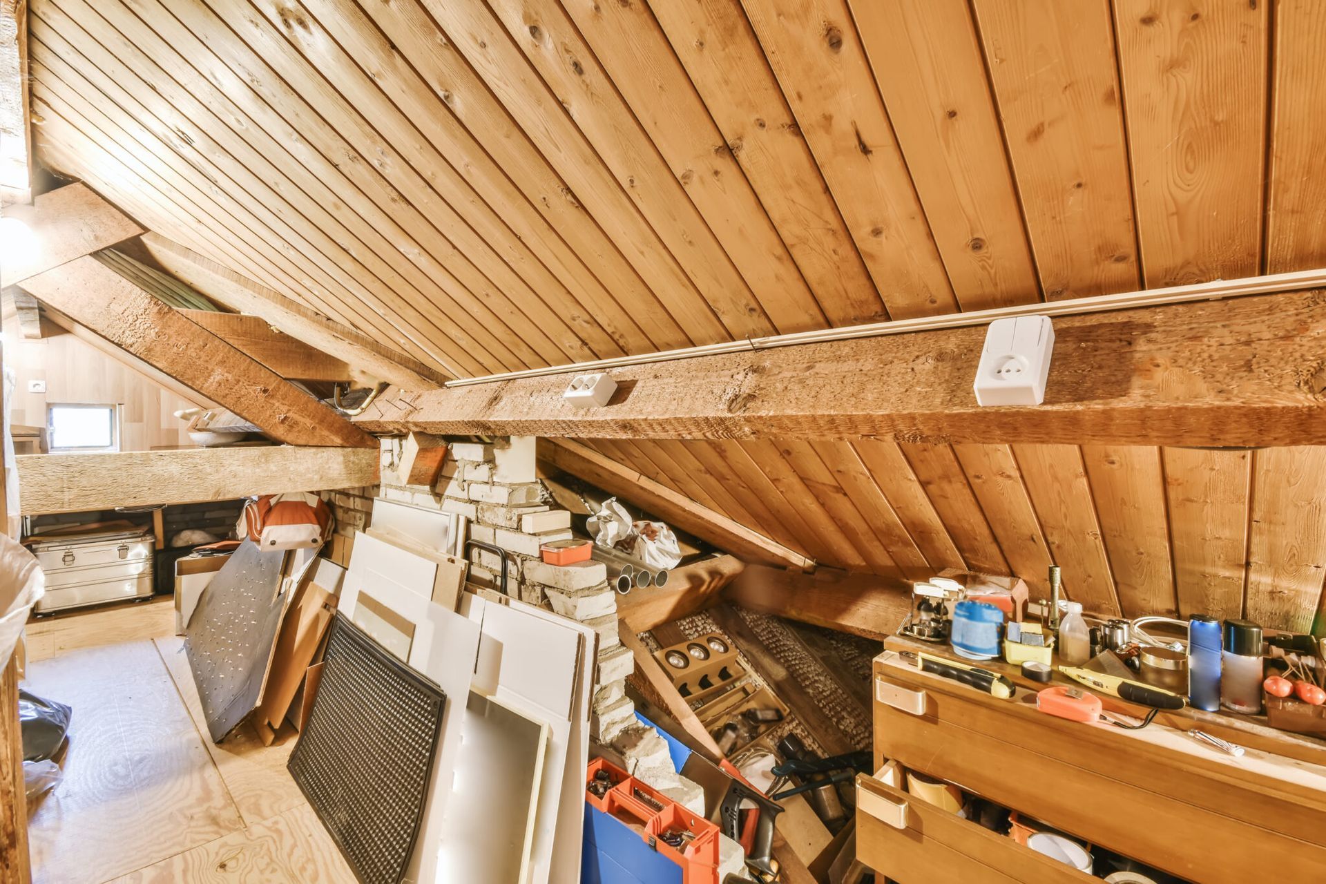 A room with a wooden ceiling and a lot of junk on the floor.