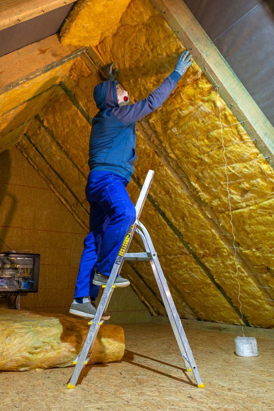 A man is measuring the ceiling with a tape measure.