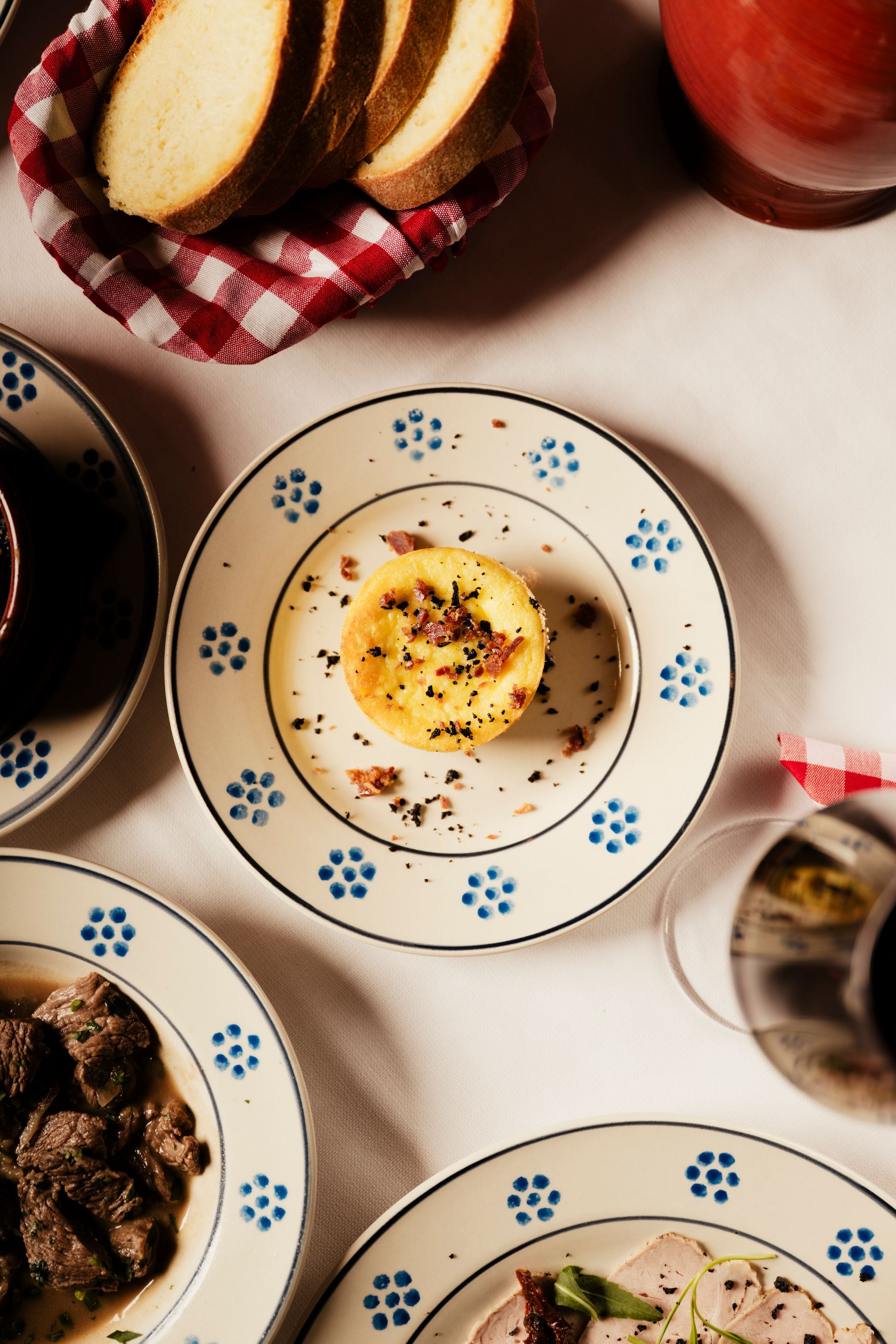 Un tavolo sormontato da piatti di cibo e un cestino di pane