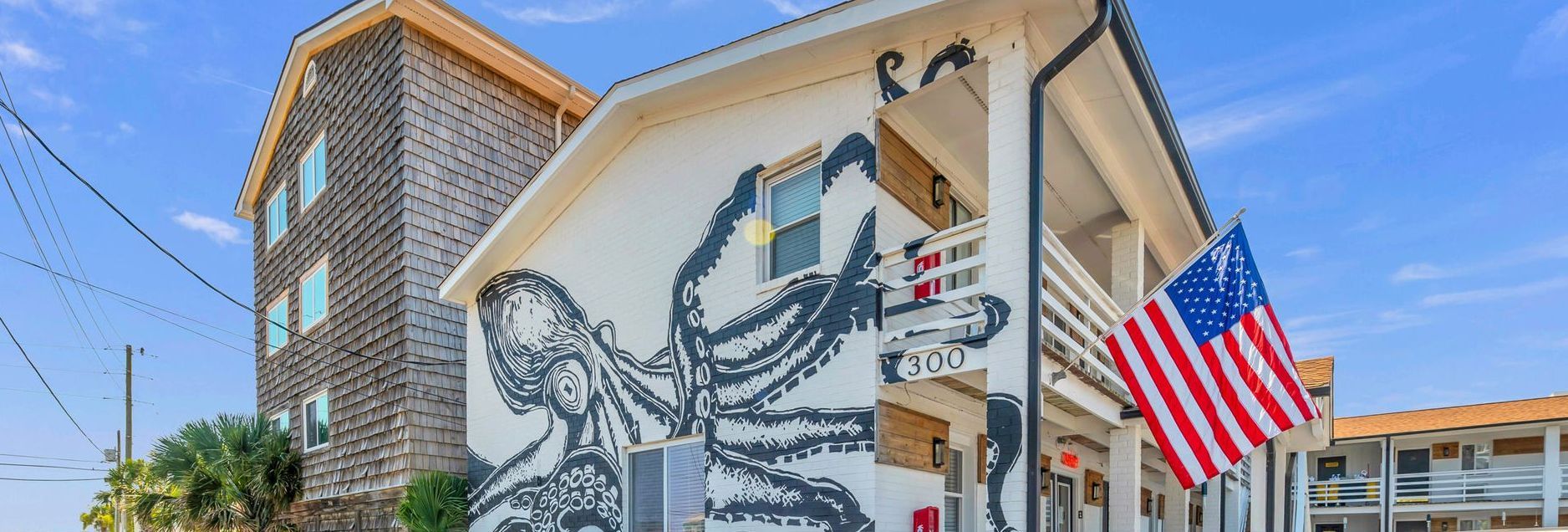 Building with an octopus mural and an American flag. Blue sky in the background.