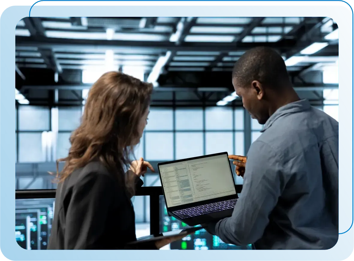 Mulher de óculos olhando para uma tela de computador exibindo código, possivelmente codificação, em um ambiente escuro.