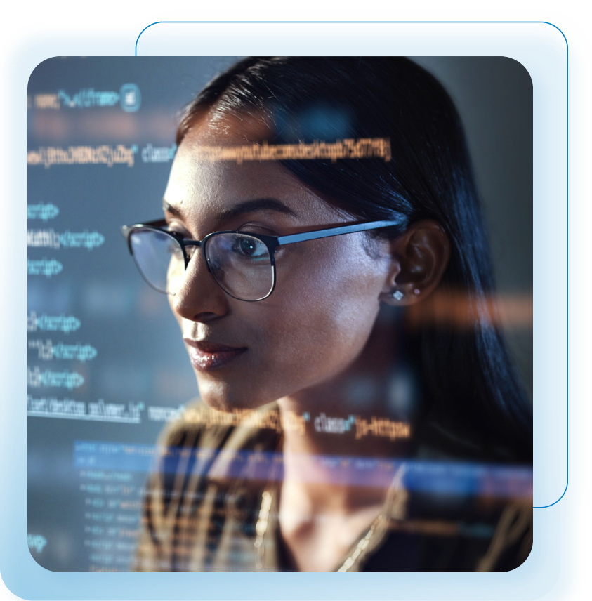 Mulher de óculos olhando para uma tela de computador exibindo código, possivelmente codificação, em um ambiente escuro.