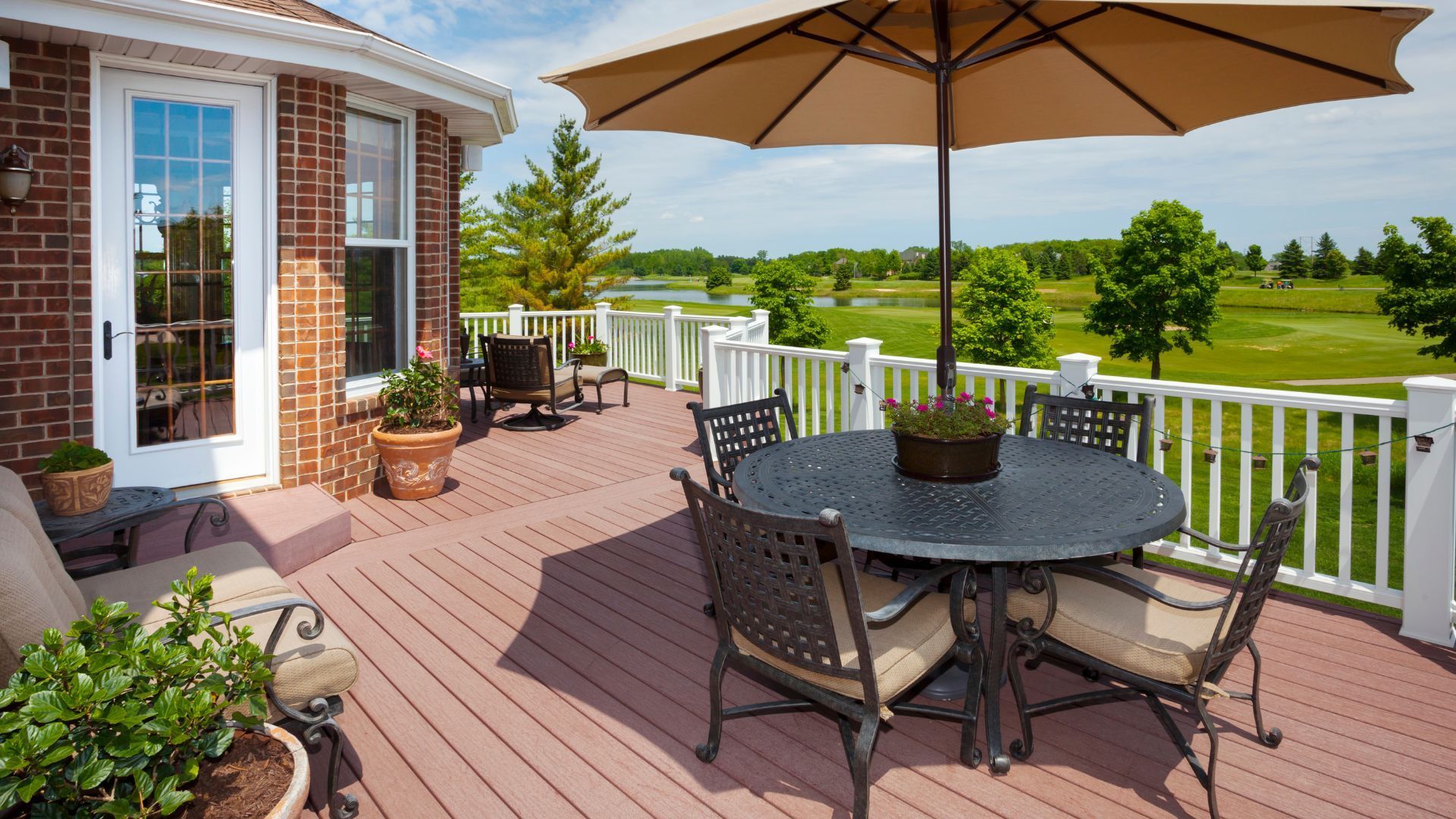 Deck in Henderson with iron furniture and golf course view, enhanced by potted plants.
