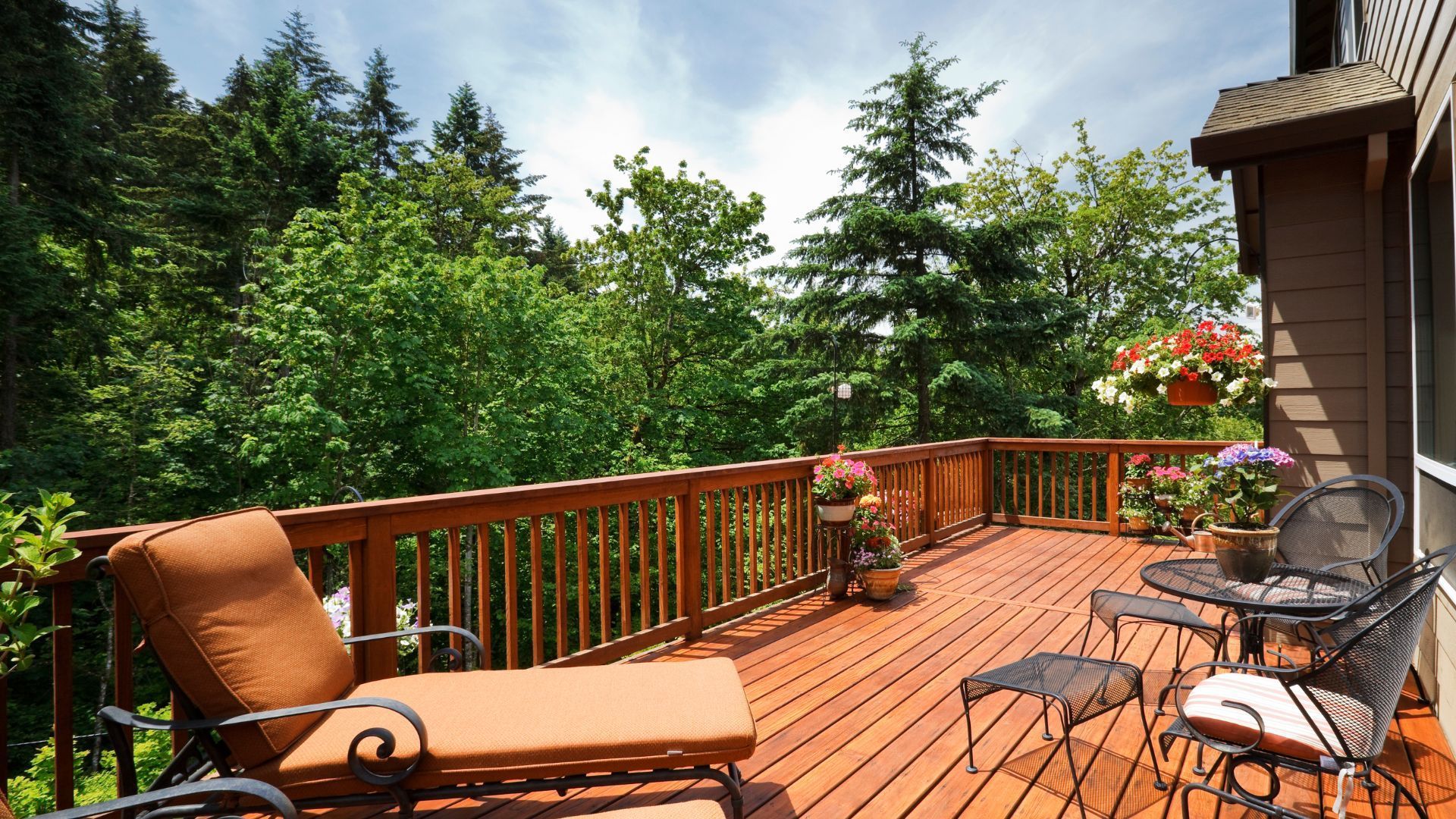 Sunny wooden deck with outdoor seating and potted plants in Henderson, NV.