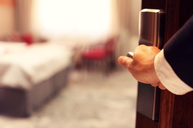 Un uomo sta aprendo una porta in una stanza d'albergo.