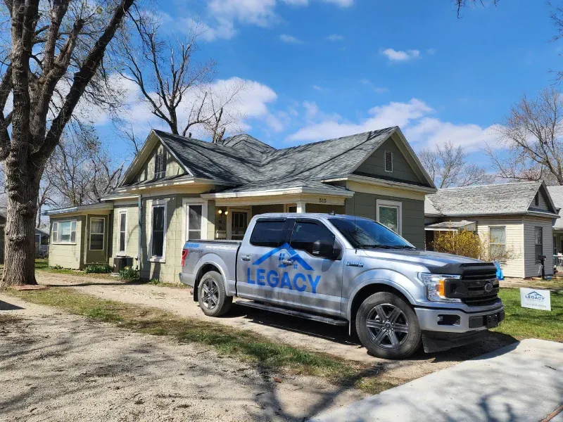 A legacy truck is parked in front of a house.