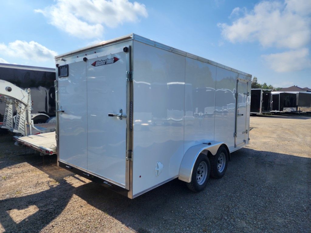 Remorque cargo blanche à double essieu, stationnée sur du gravier.