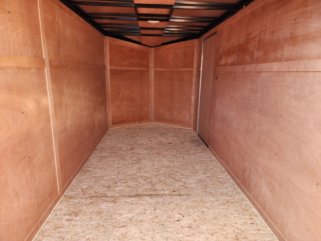 Intérieur de remorque de chargement vide, boiseries, plancher en aggloméré, vue depuis l'entrée.