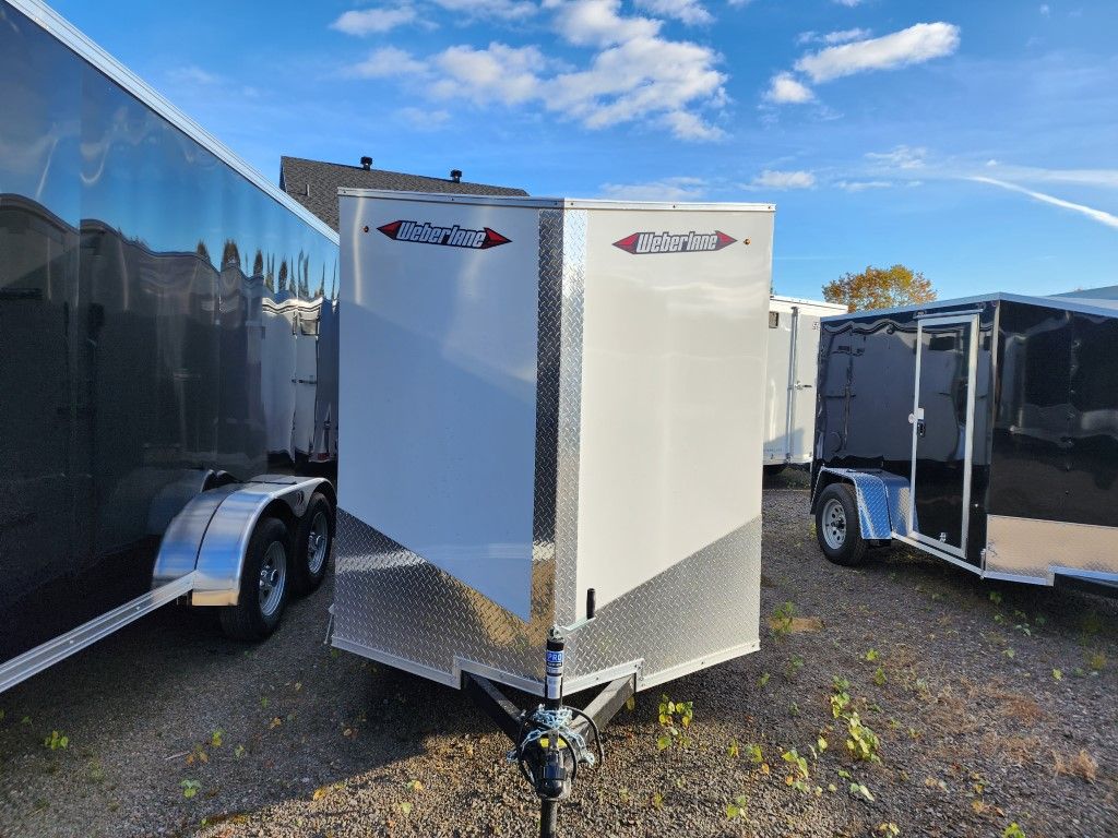 Remorque fermée blanche avec placage diamant, ciel bleu.