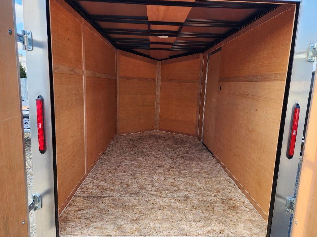 À l'intérieur d'une remorque cargo vide avec parois et plancher en bois, ouverte sur l'extérieur.