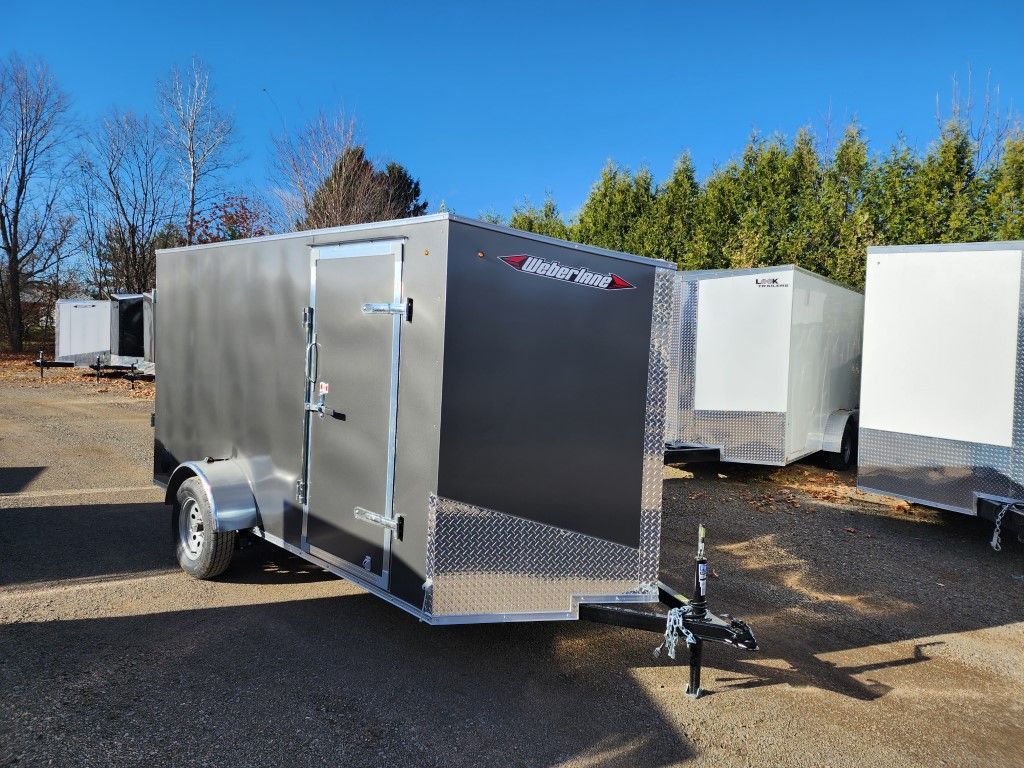 Une rangée de remorques est garée sur un terrain en gravier.