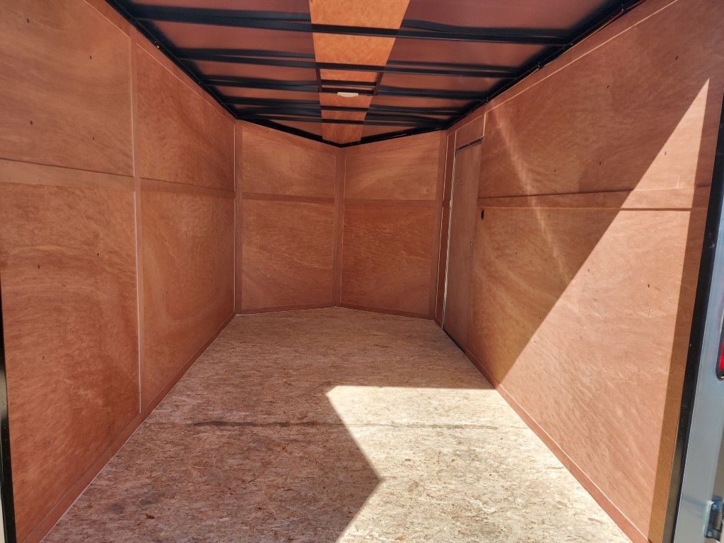 À l'intérieur d'une remorque cargo vide avec des panneaux de bois et une porte.