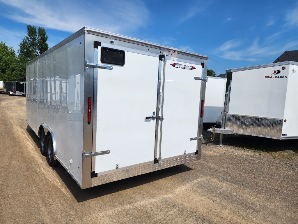 Remorque cargo blanche avec portes doubles et cadre en aluminium, stationnée à l'extérieur sur du gravier.