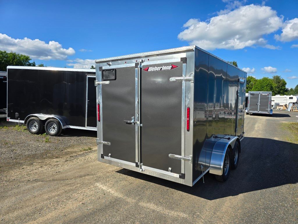 Remorque cargo grise avec portes doubles garée à l'extérieur par une journée ensoleillée.