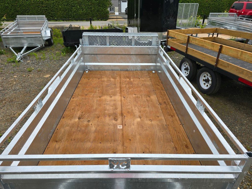 Une remorque avec un plancher en bois est garée à côté d'un camion.