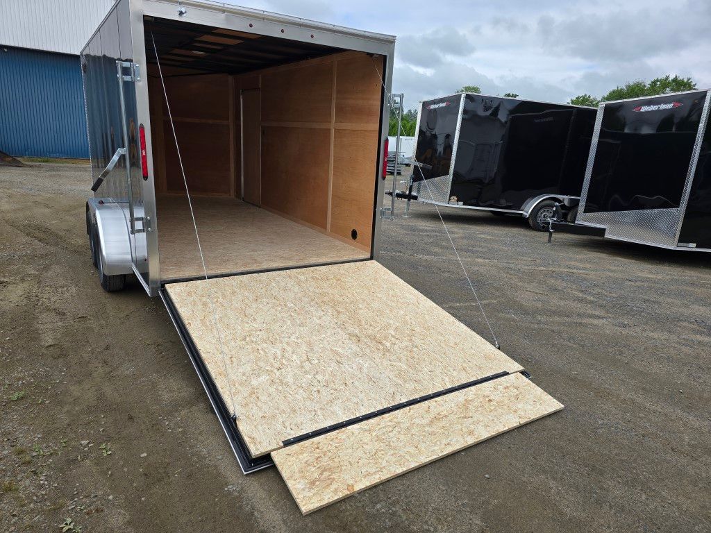 Une remorque avec la porte ouverte est garée sur un parking.