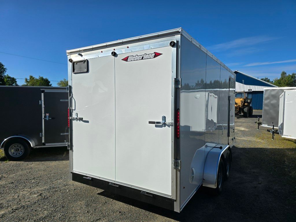 Remorque cargo fermée argentée avec portes doubles, garée à l'extérieur par une journée ensoleillée.