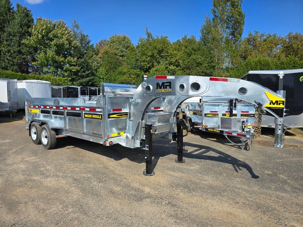 Une grande remorque MR argentée stationnée à l'extérieur, avec un attelage noir et plusieurs compartiments.