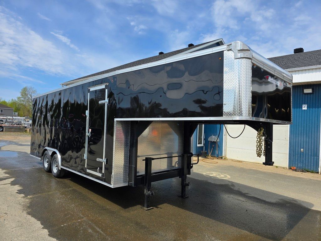 Une remorque noire est garée devant un bâtiment.