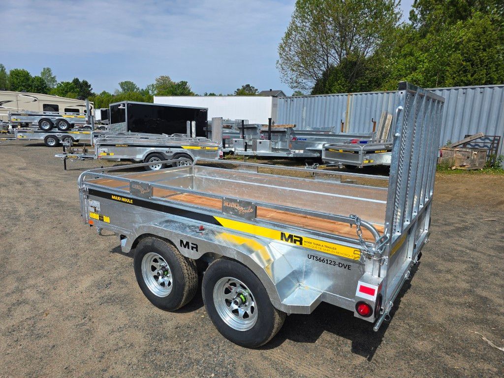 Une remorque est garée sur un parking à côté d'un bâtiment.