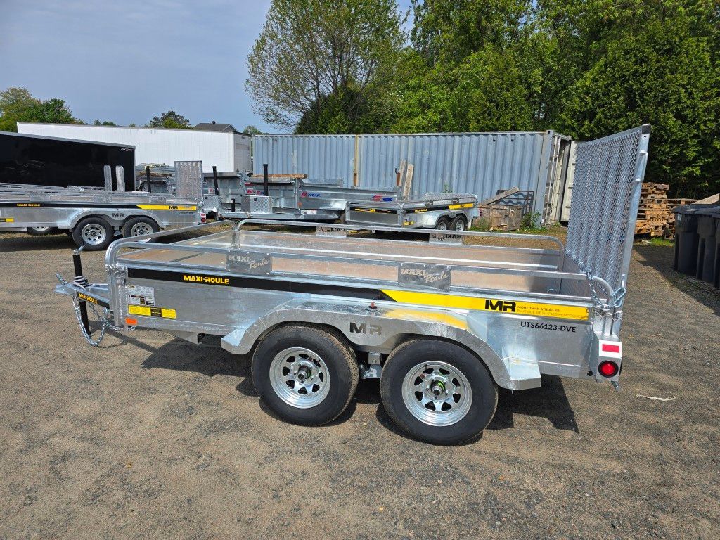 Une remorque est garée sur un terrain en terre à côté d'une clôture.