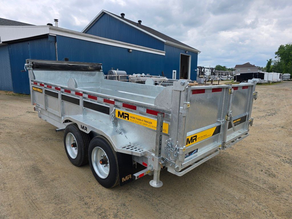 Remorque à benne argentée garée à l'extérieur, près d'un bâtiment bleu, avec le nom de marque « MR ».
