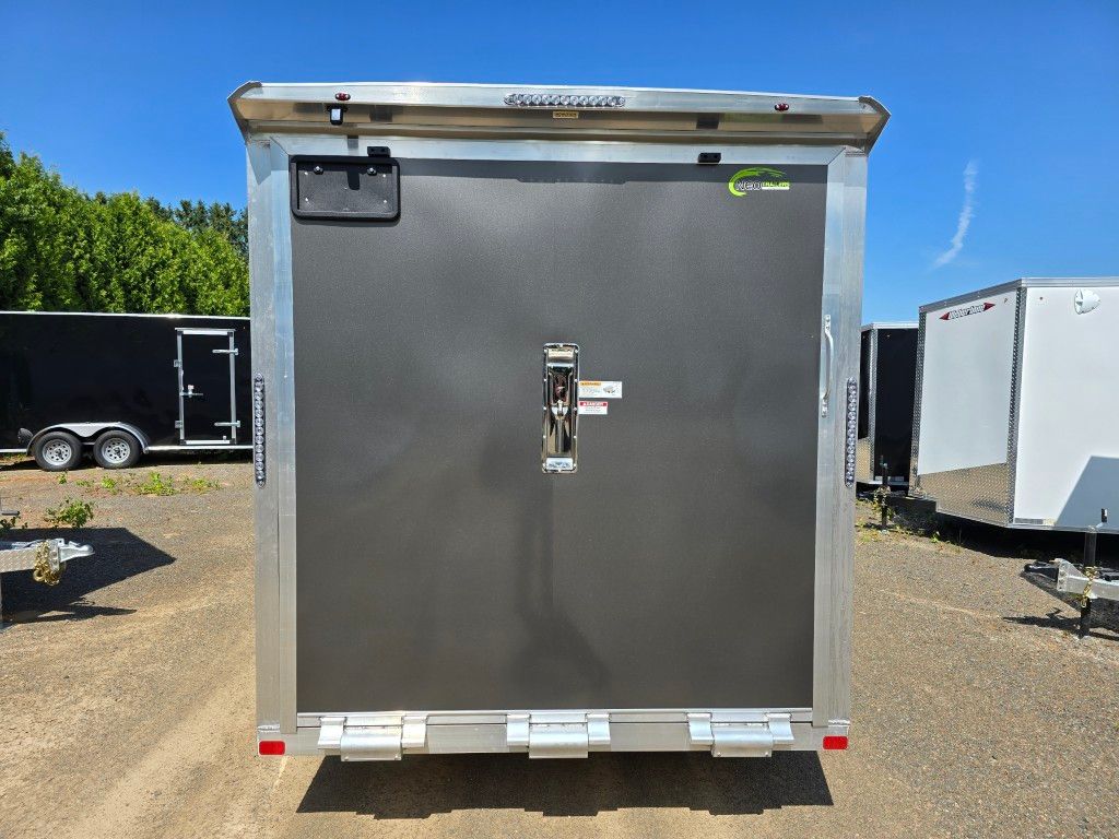 Vue arrière d'une remorque cargo argentée et grise avec une porte fermée, à l'extérieur.