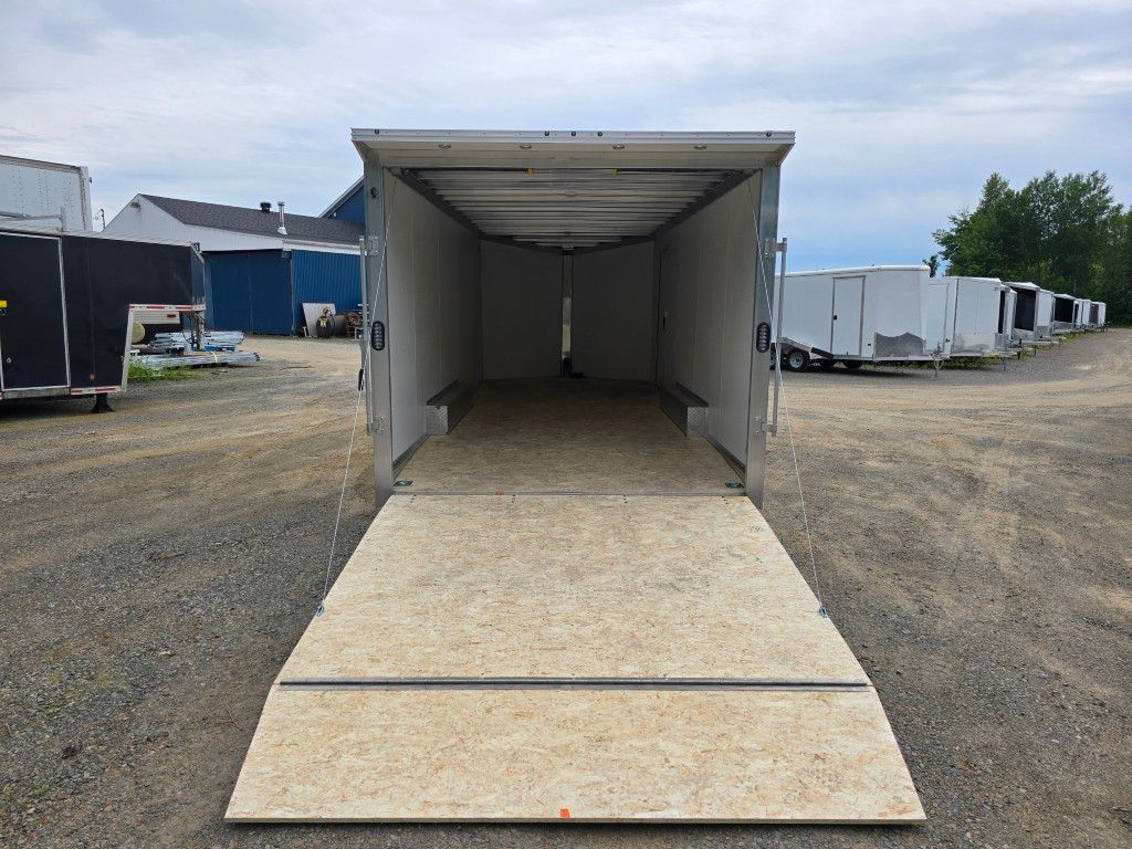 Une remorque est garée sur un parking avec la porte ouverte.