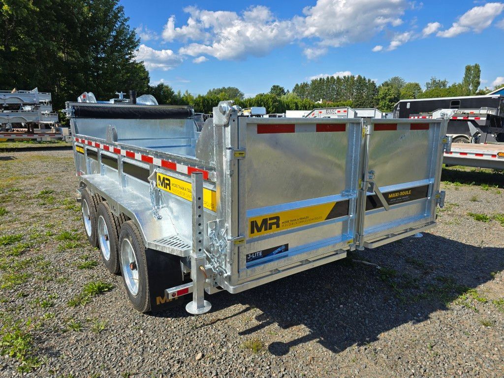 Remorque à benne argentée sur l'herbe, avec des accents jaunes et noirs, sous un ciel bleu.