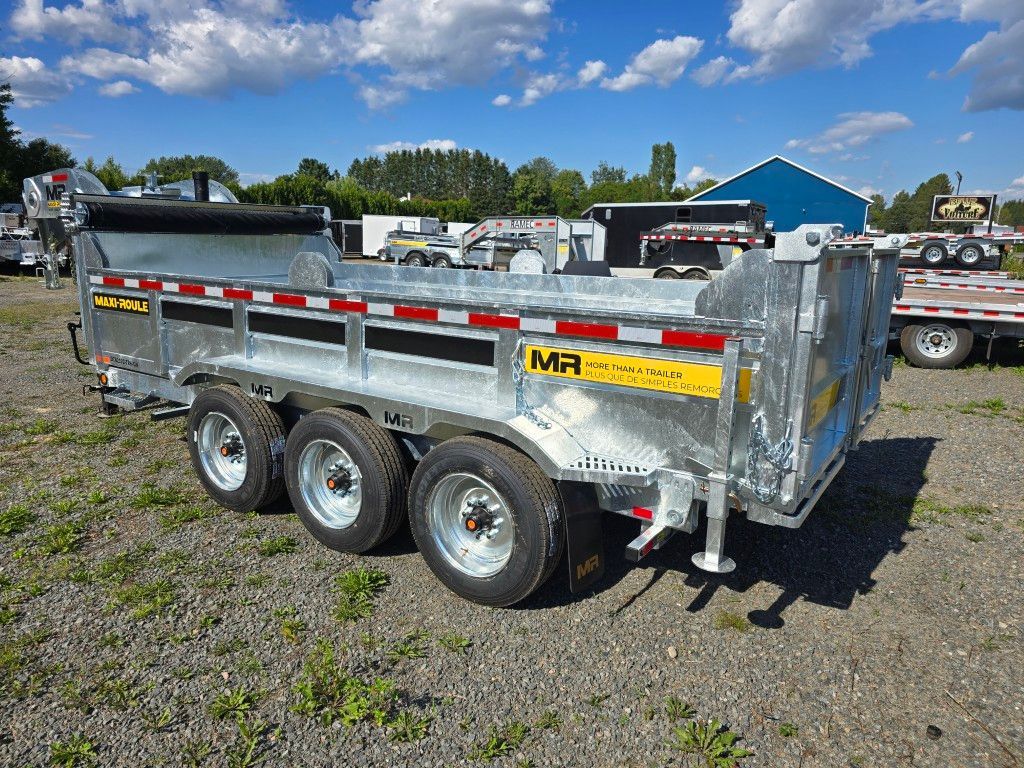 Remorque à benne basculante argentée à trois essieux sur terrain en gravier sous ciel bleu.