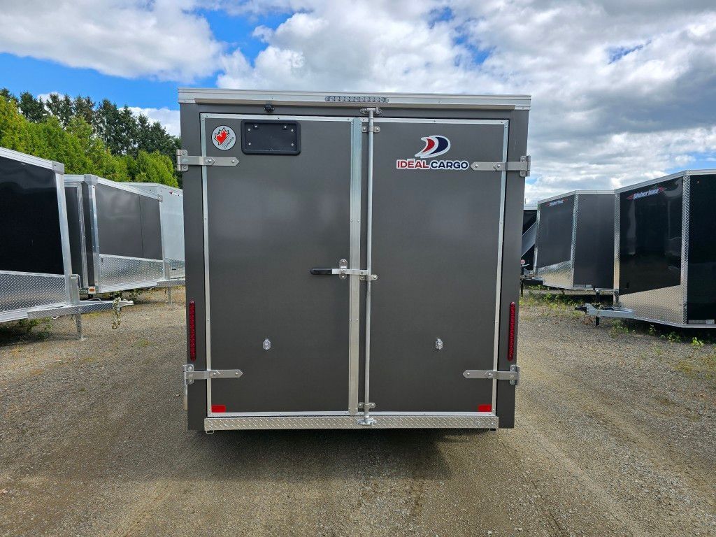 Remorque cargo grise avec portes fermées, stationnée à l'extérieur.