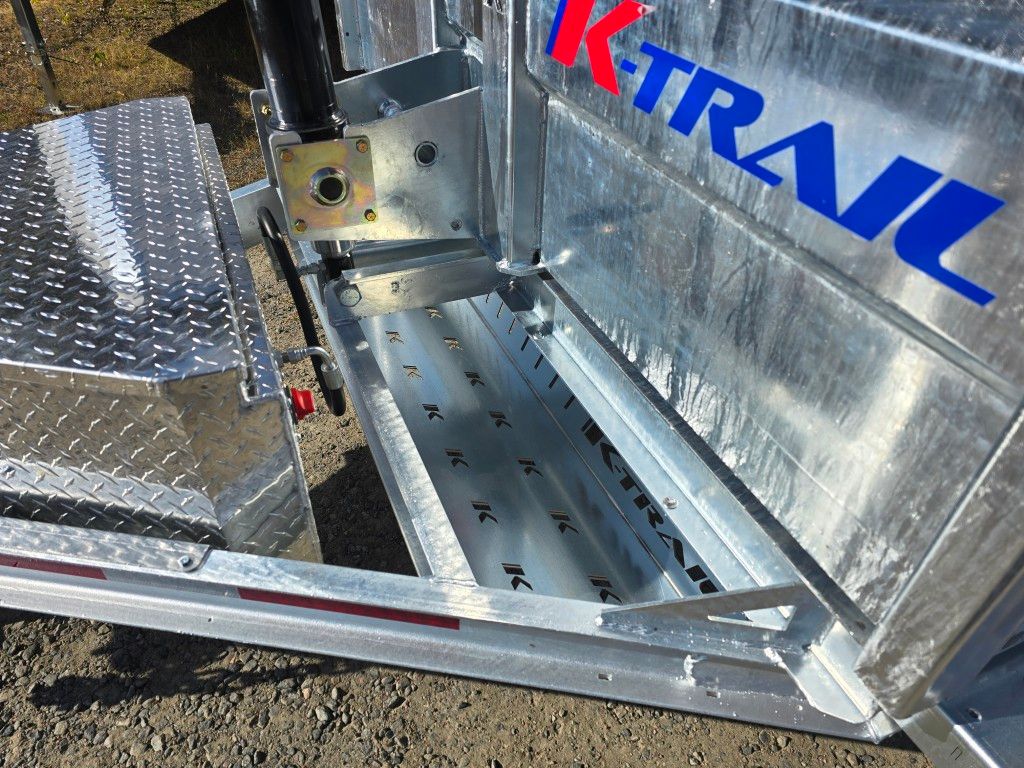 Gros plan d'une rampe de remorque et d'un compartiment de rangement en aluminium K-TRAIL, avec marchepied et attelage visibles.