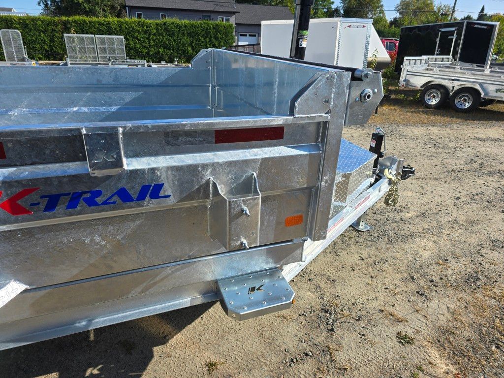 Gros plan d'une remorque à benne basculante X-Trail argentée, montrant l'arrière avec une marche et un feu arrière.