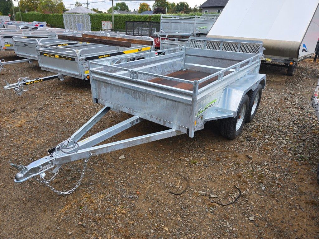Remorque utilitaire galvanisée à deux roues, stationnée sur gravier.