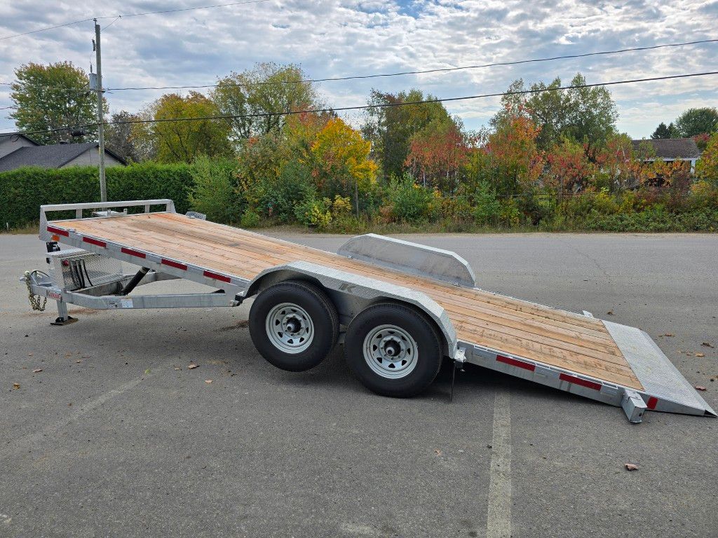 Remorque grise et argent avec plateau en bois, stationnée à l'extérieur.