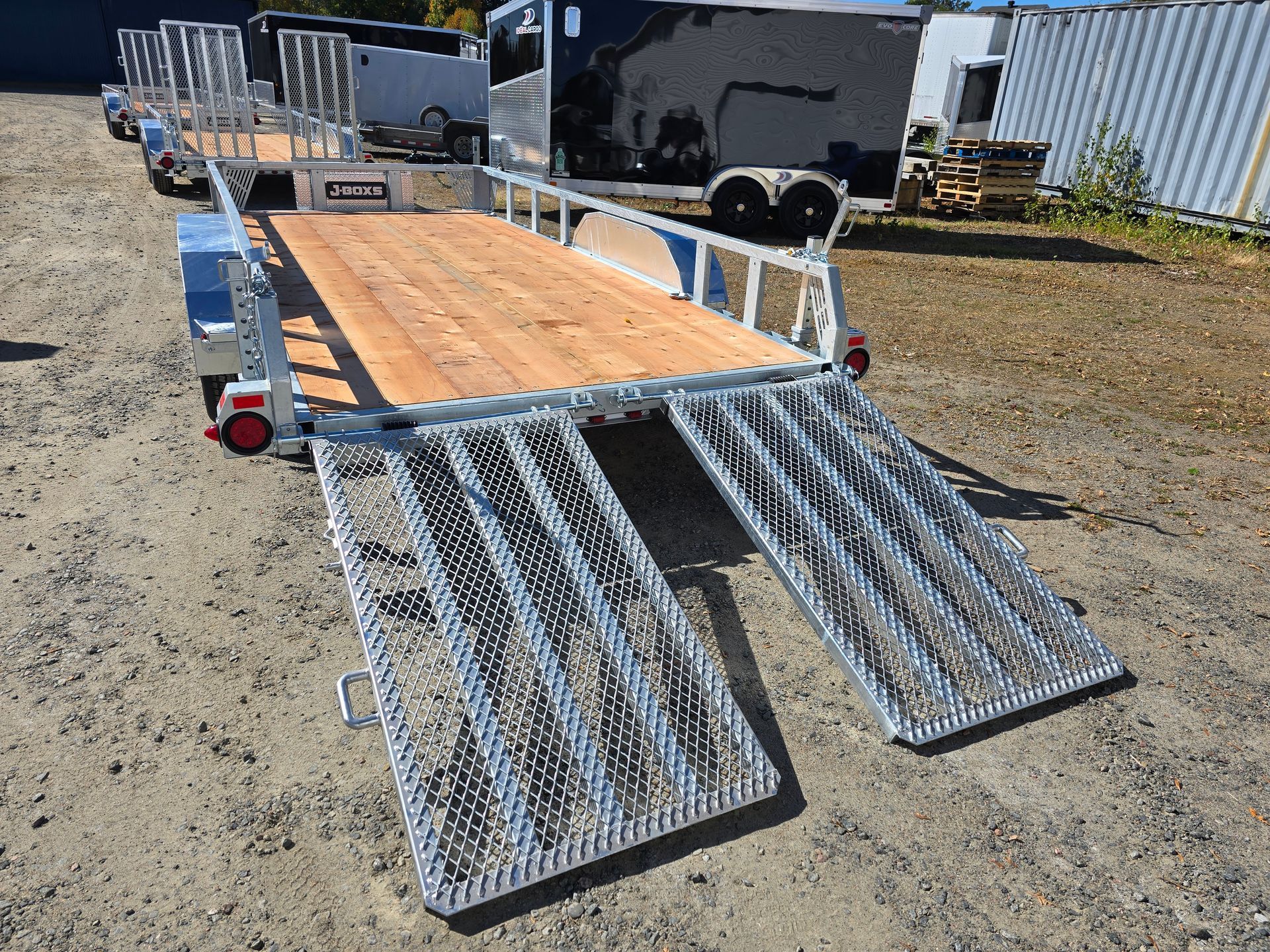 Remorque à deux rampes avec plancher en bois, prête à charger. Extérieur.