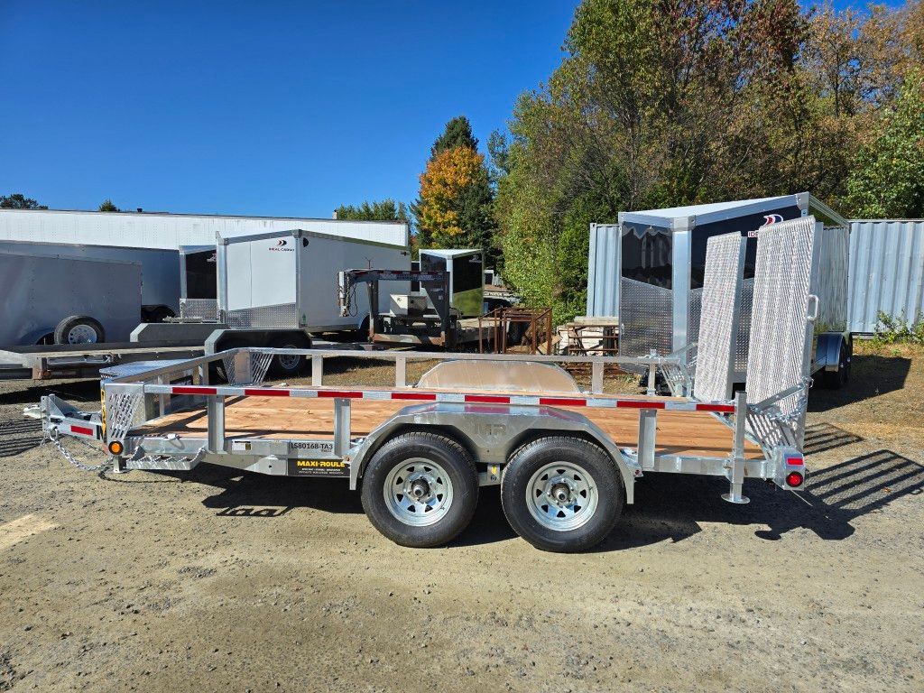 Remorque stationnée à l'extérieur avec rampe, terrasse en bois et deux essieux.