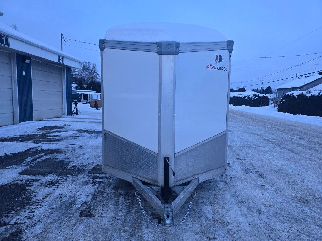 Remorque cargo blanche dans un décor extérieur enneigé.