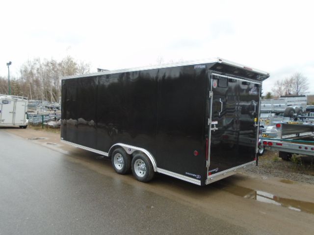 Remorque cargo fermée noire garée à l'extérieur sur l'asphalte.