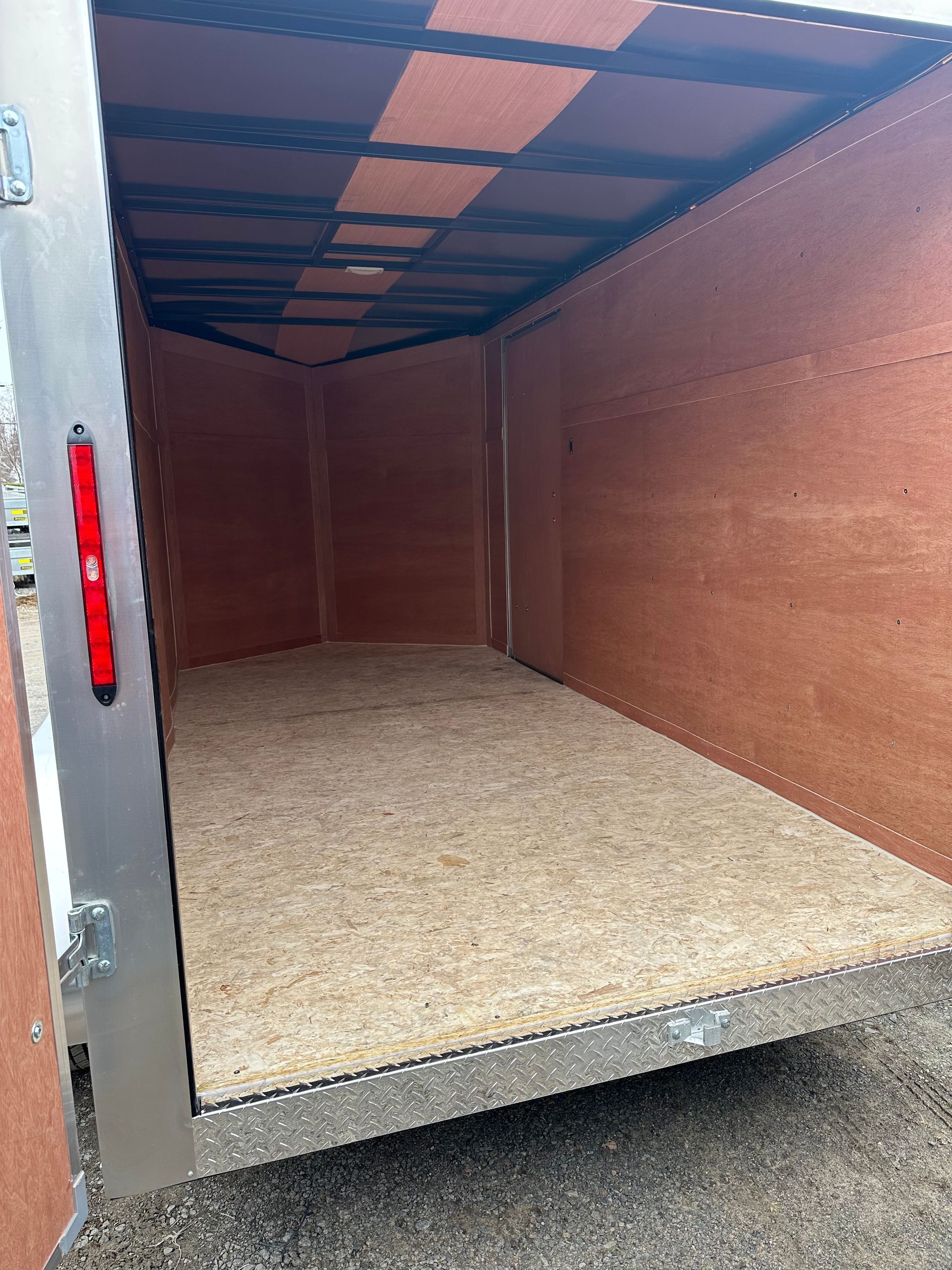 Intérieur de remorque de chargement vide avec murs et plancher lambrissés de bois.