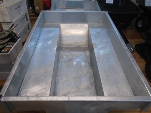 Une remorque sur laquelle est écrit « aluminium » est sur un plancher en bois