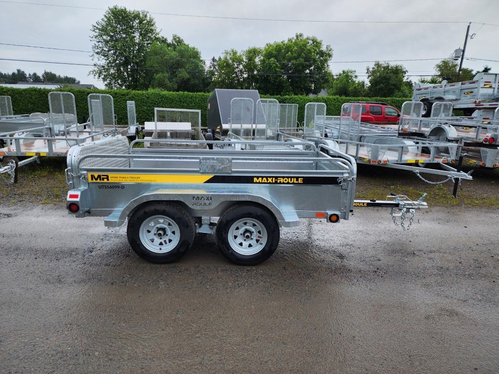 Une remorque est garée devant une rangée de remorques.