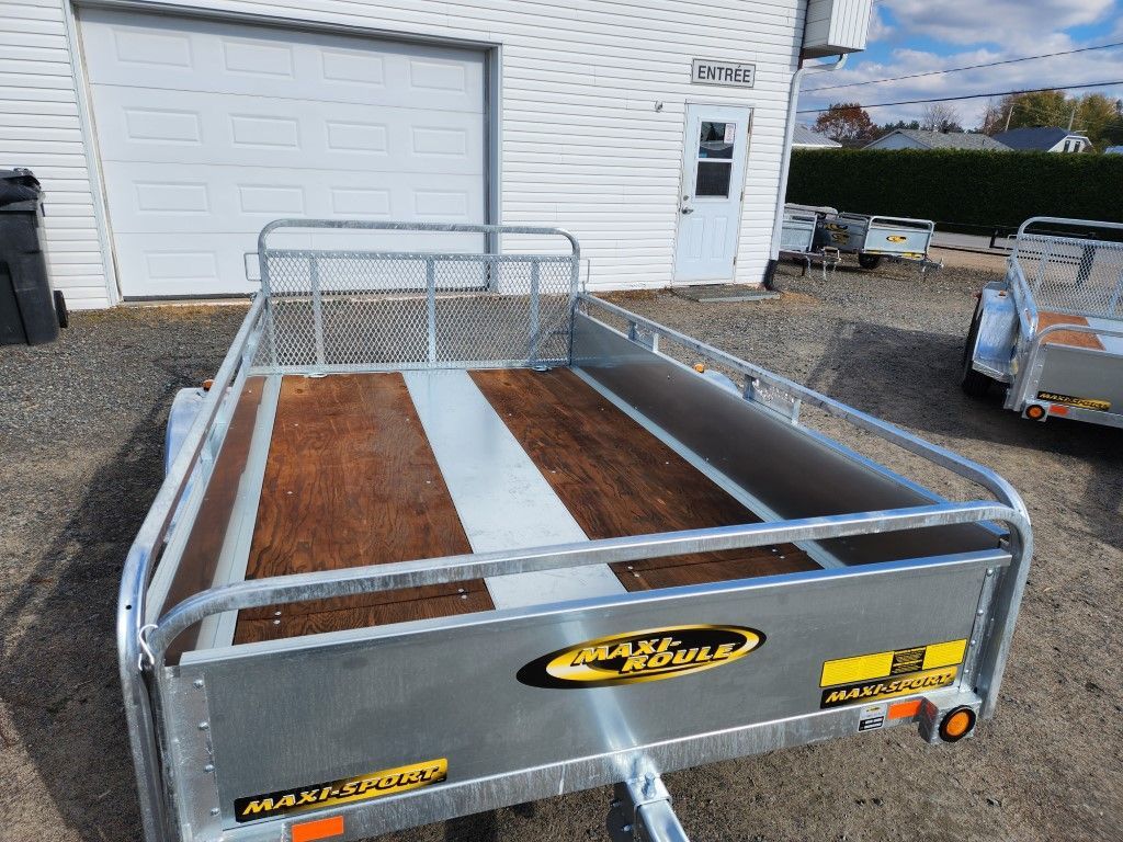 Une remorque est garée devant une porte de garage.