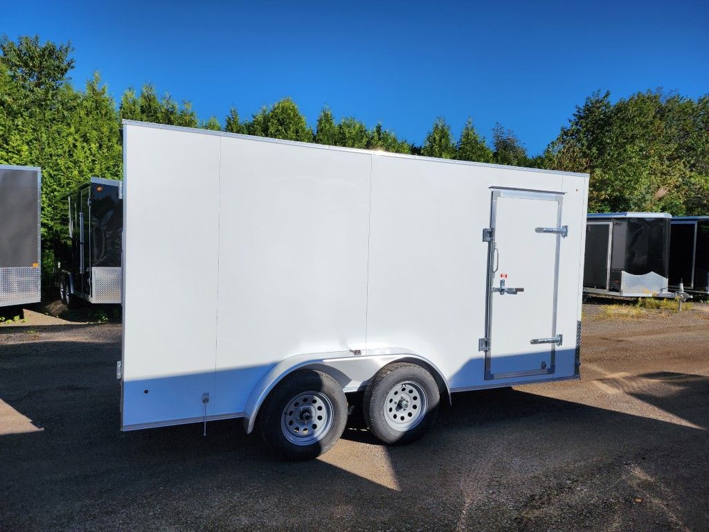 Une remorque blanche est garée sur un parking.