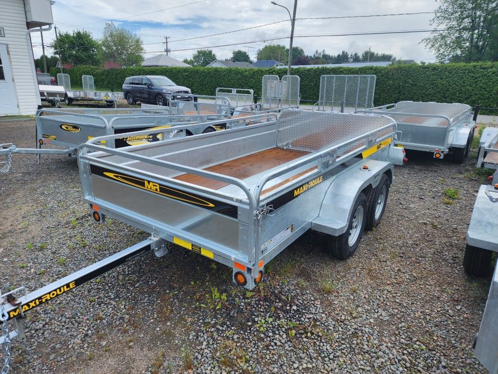 Une rangée de remorques est garée sur un terrain en gravier.