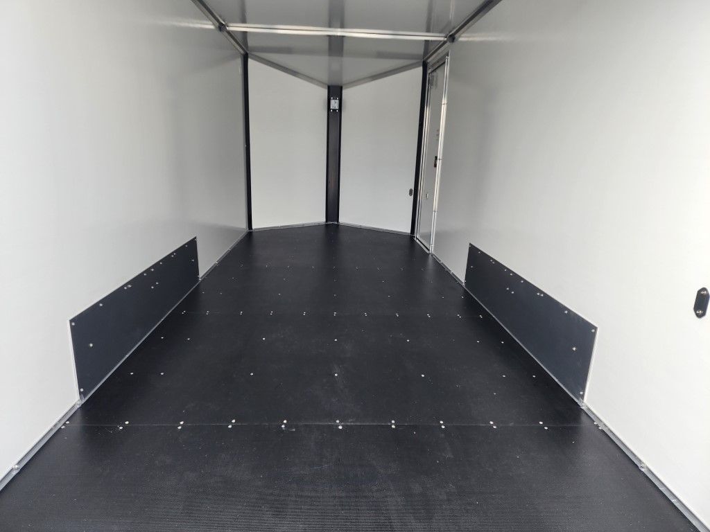 Une remorque vide avec un sol noir et des murs blancs